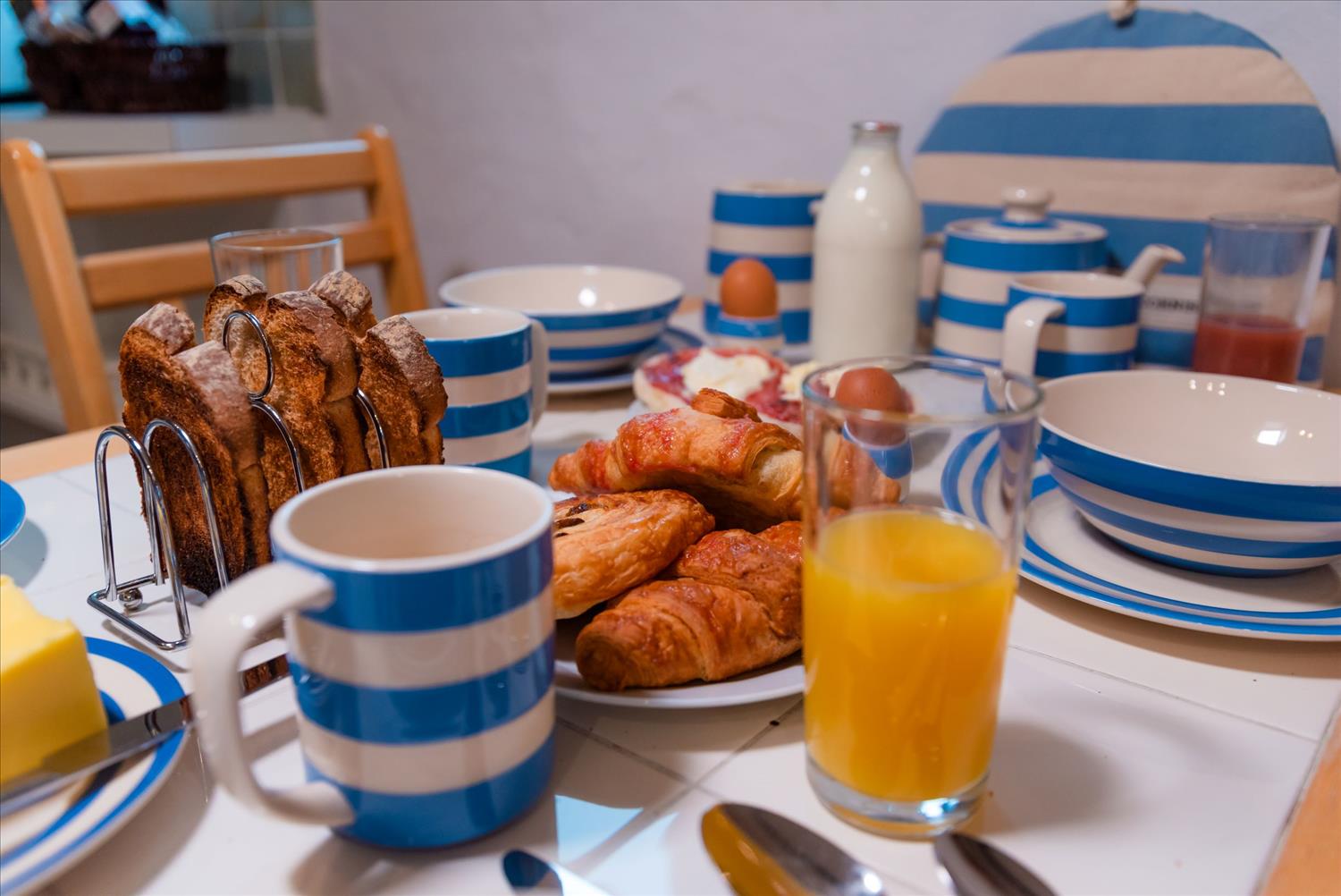 The table of one of Polrunny Farm's cottages, with the traditional blue and white tableware set out for breakfast