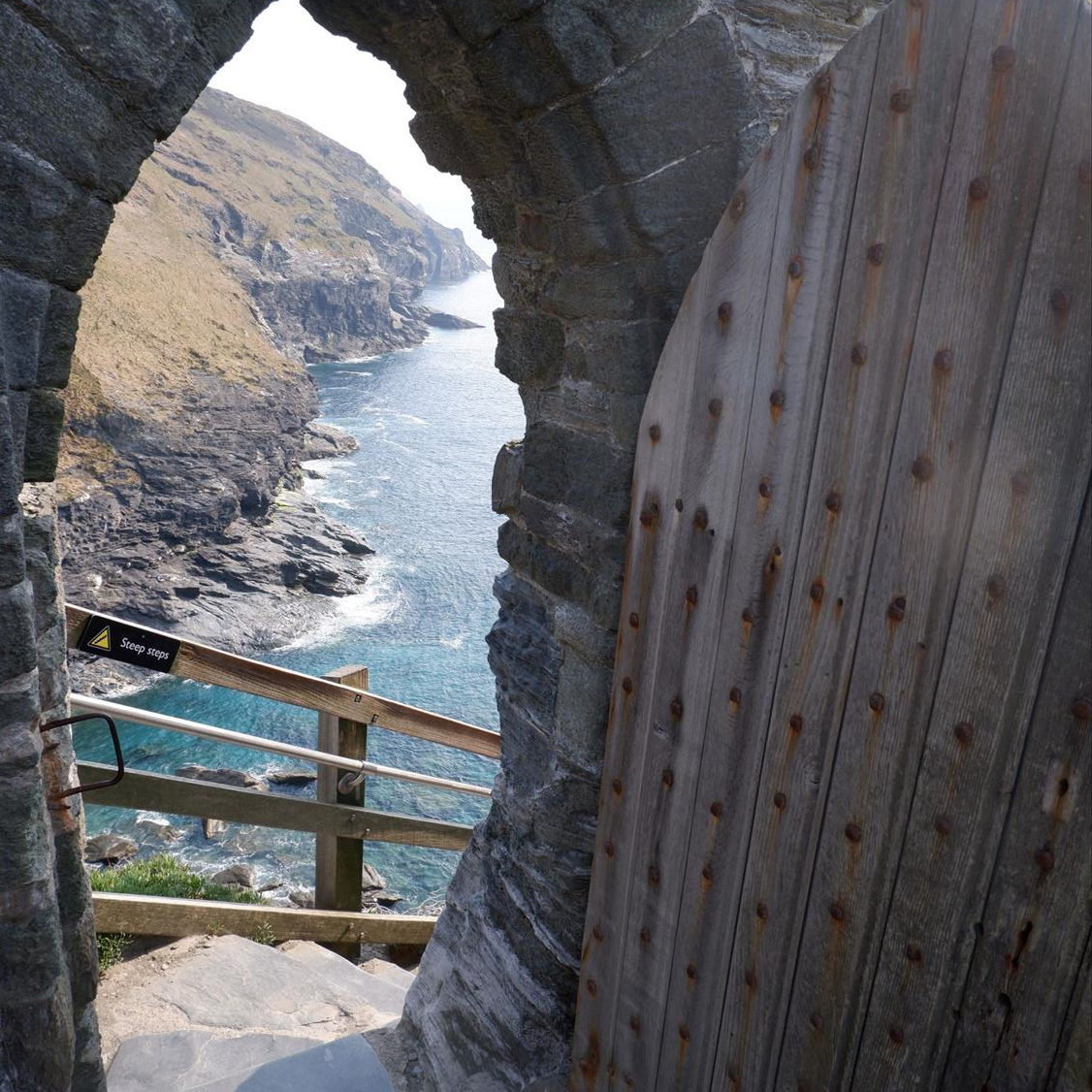 Tintagel Castle, with the heavy wooden gate open to reveal steps down to the sea