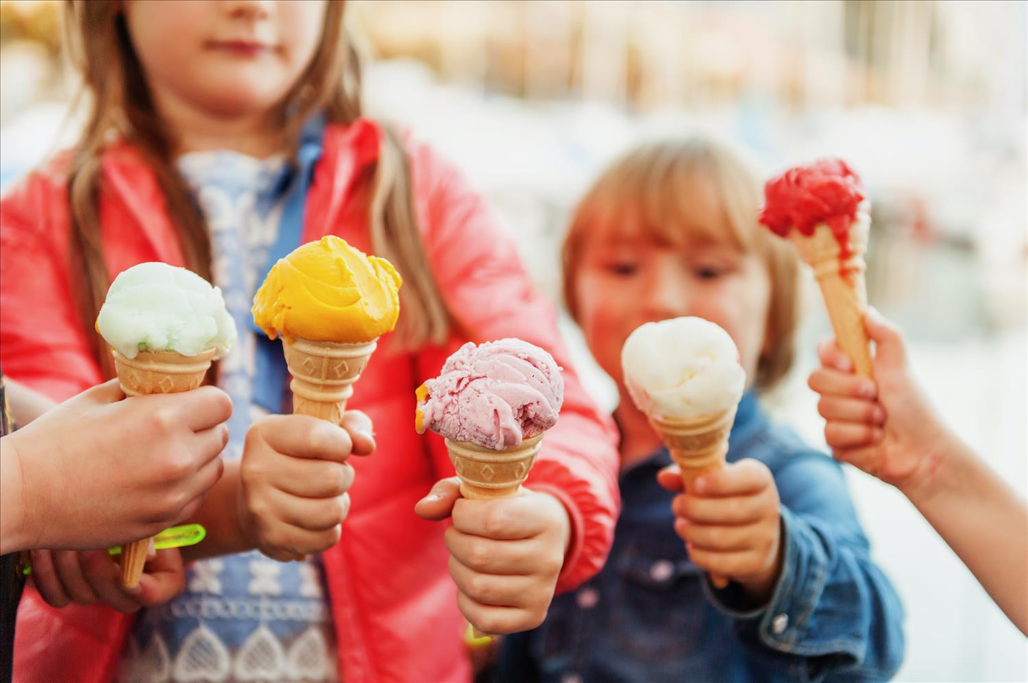 children eating brightly coloured ice creams on their holiday in Cornwall
