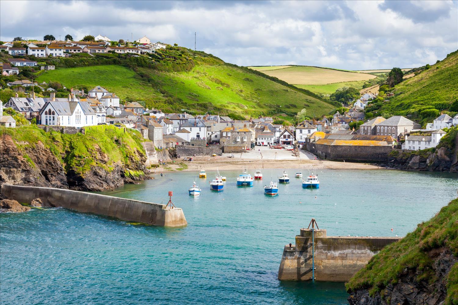 The tide is in at Port Isaac, home to ITV's Doc Martin, with boats floating in the harbour and the town's white stone houses rising up the hillside