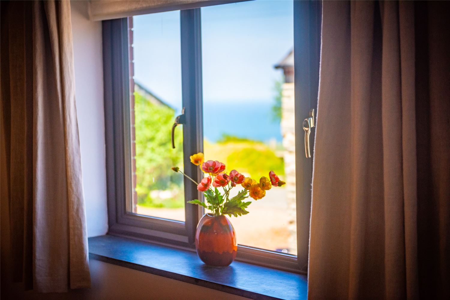 The sea view from Polrunny Farm's colourful and artistic Sloe Cottage